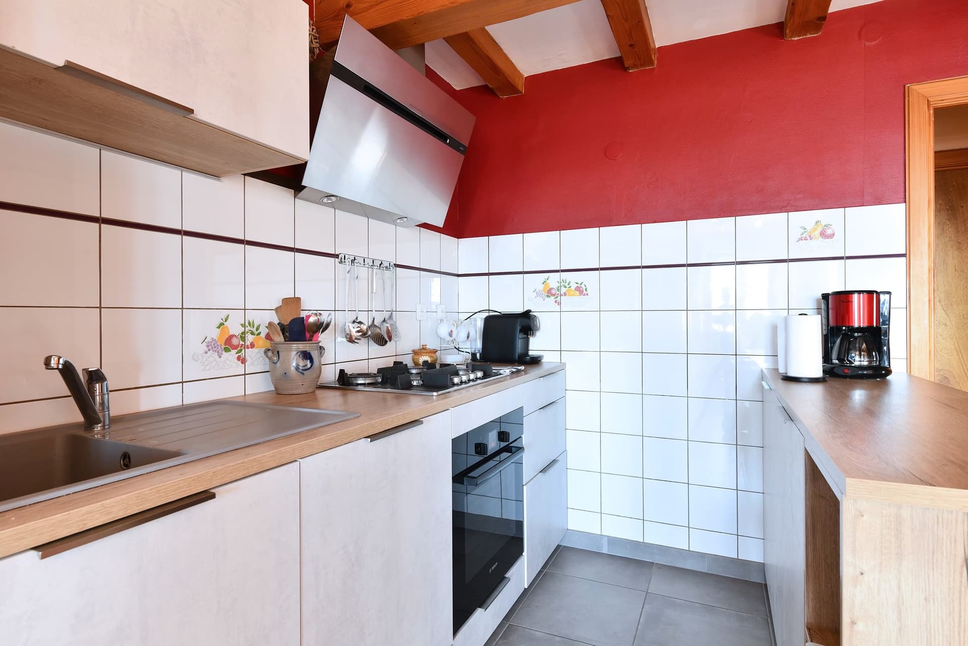 Cuisine équipée avec hotte, plaques de cuisson et four intégré.