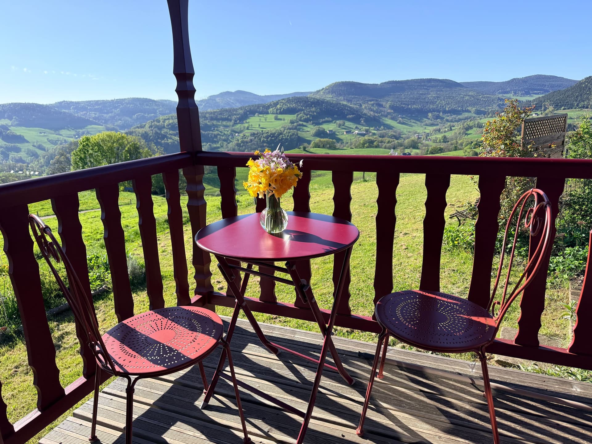 Terrasse privée de la roulotte, table ronde et vue sur la vallée.